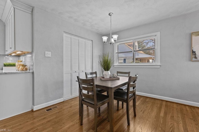 dining area with an inviting chandelier and wood-type flooring