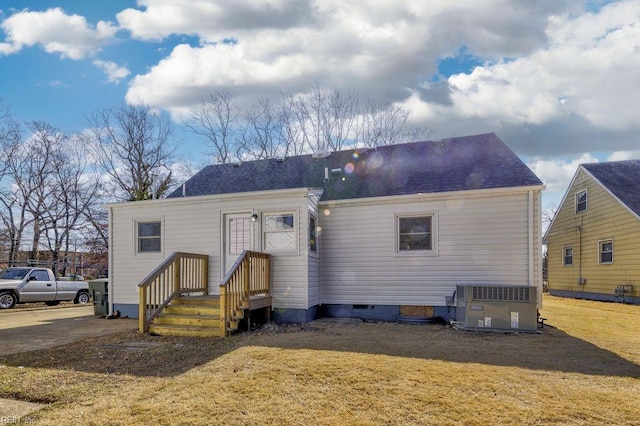 view of front of home with central AC unit and a front lawn