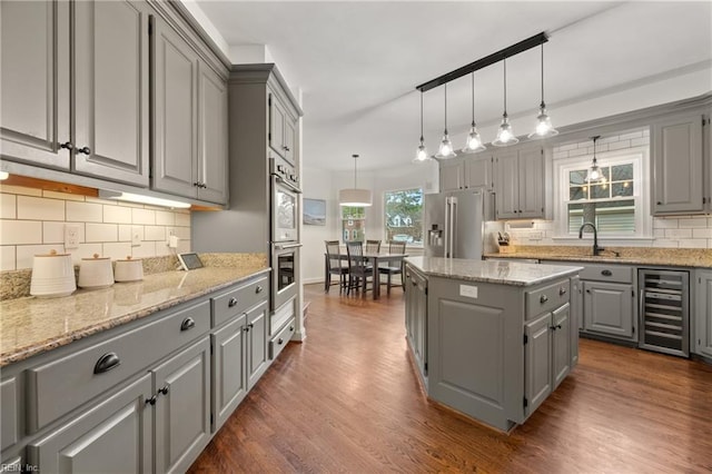 kitchen featuring wine cooler, high end fridge, a center island, gray cabinets, and pendant lighting