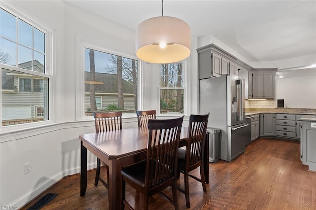 dining area featuring a healthy amount of sunlight and dark hardwood / wood-style flooring