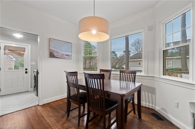 dining space featuring dark hardwood / wood-style flooring and washer / clothes dryer