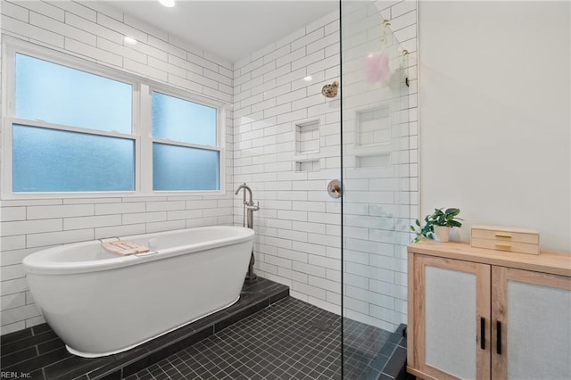 bathroom with tile walls, tile patterned floors, and independent shower and bath