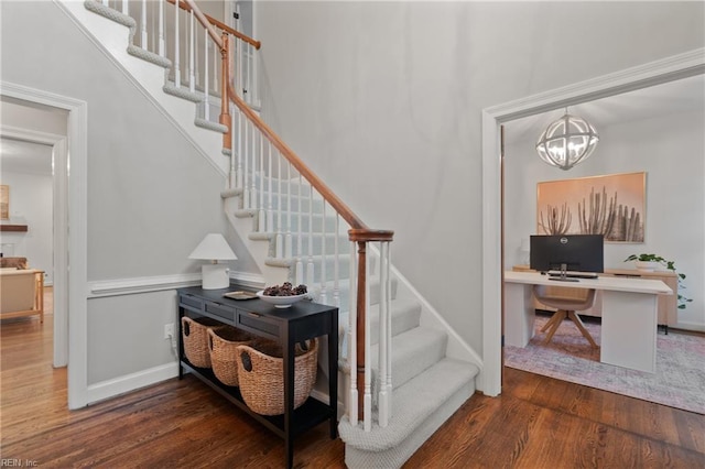 stairs with an inviting chandelier, hardwood / wood-style floors, and a high ceiling