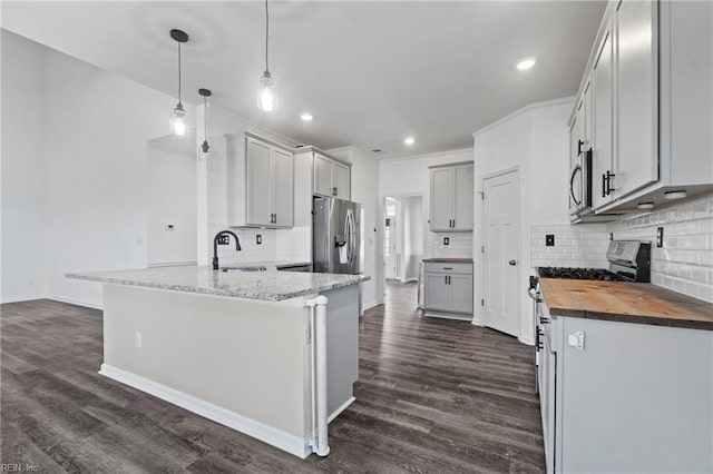 kitchen with wooden counters, dark hardwood / wood-style flooring, sink, and hanging light fixtures