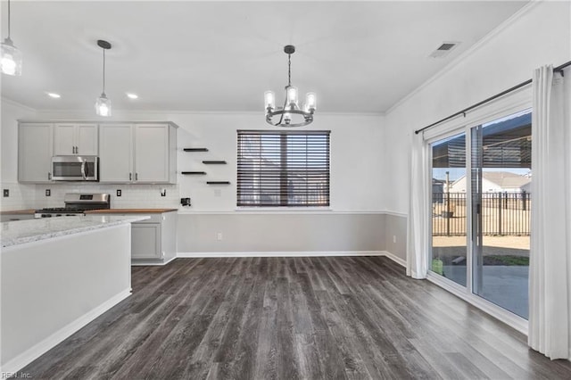 kitchen featuring hanging light fixtures, stainless steel appliances, ornamental molding, light stone countertops, and dark hardwood / wood-style flooring