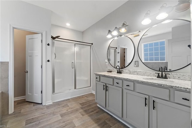 bathroom featuring vanity, a shower with shower door, and wood-type flooring