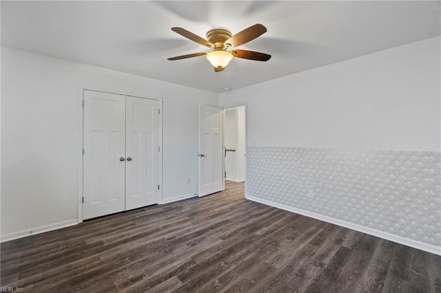 unfurnished bedroom with dark wood-type flooring, ceiling fan, and a closet