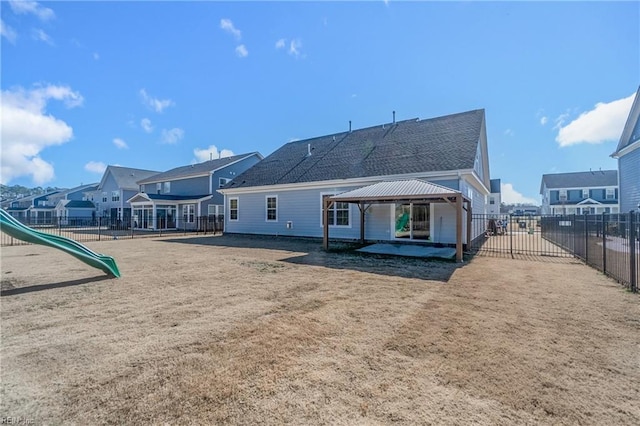 back of house with a gazebo and a playground