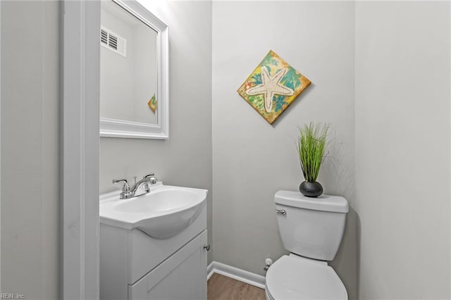 bathroom with vanity, hardwood / wood-style flooring, and toilet