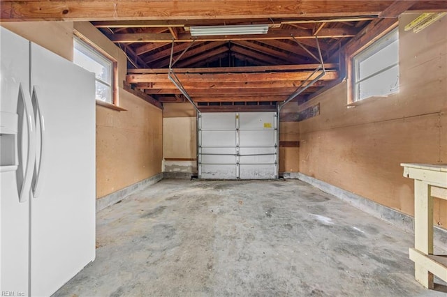 garage featuring white fridge with ice dispenser