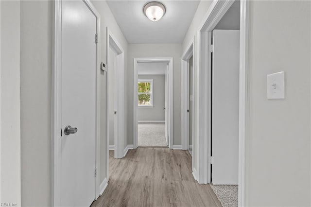 hallway with light hardwood / wood-style floors