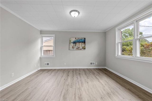 unfurnished room featuring ornamental molding and light wood-type flooring