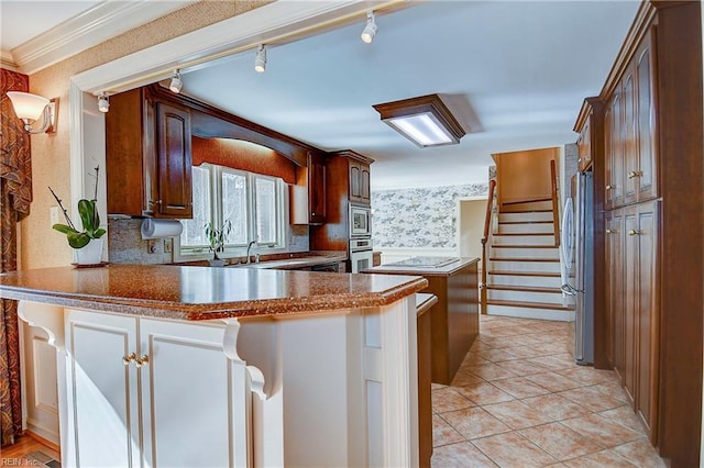 kitchen with crown molding, stainless steel appliances, kitchen peninsula, and light tile patterned floors