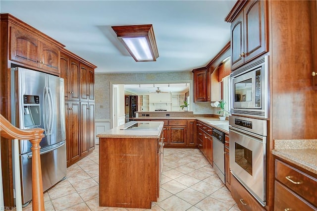 kitchen featuring light tile patterned floors, stainless steel appliances, and a kitchen island