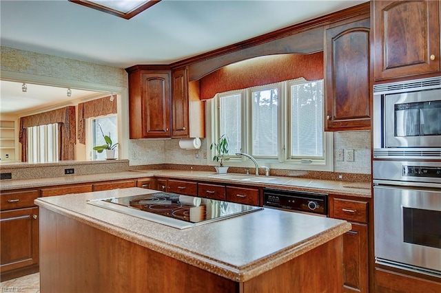 kitchen featuring tasteful backsplash, a center island, sink, and black appliances