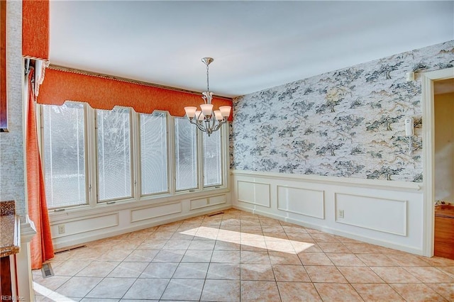 unfurnished dining area with light tile patterned floors and an inviting chandelier