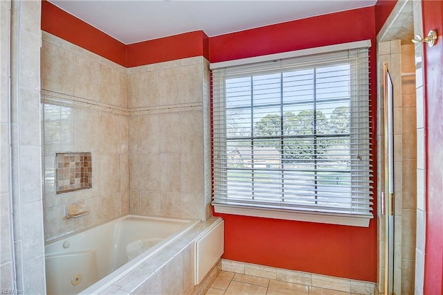 bathroom featuring tile patterned flooring and a relaxing tiled tub