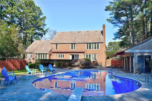 view of pool with a patio area and a diving board