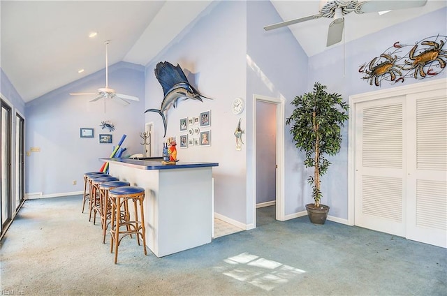 kitchen featuring carpet floors, high vaulted ceiling, a breakfast bar, and ceiling fan