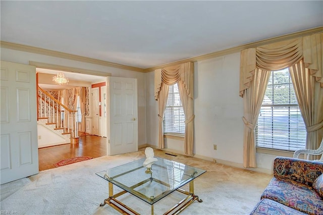 carpeted living room featuring ornamental molding, a wealth of natural light, and a chandelier