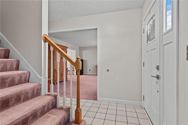 tiled foyer entrance with a textured ceiling