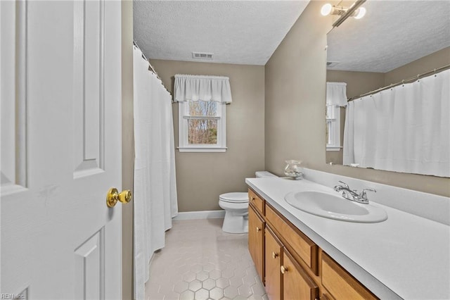 bathroom with vanity, tile patterned floors, toilet, and a textured ceiling