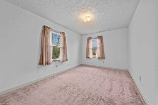 carpeted spare room featuring a textured ceiling