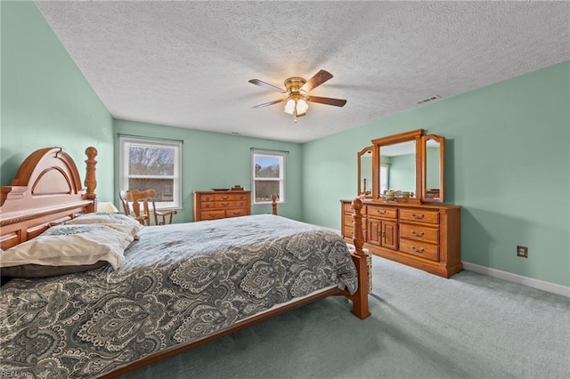 carpeted bedroom featuring ceiling fan and a textured ceiling