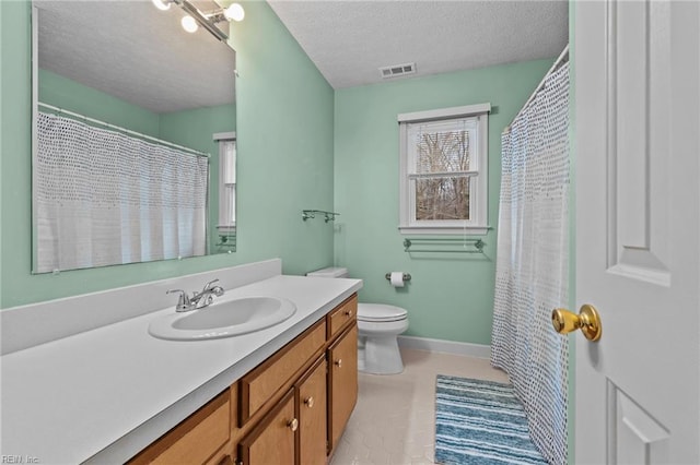 bathroom featuring vanity, toilet, and a textured ceiling