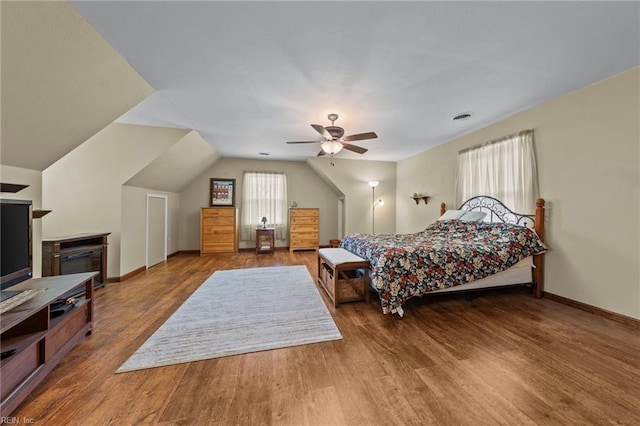 bedroom featuring multiple windows, hardwood / wood-style floors, lofted ceiling, and ceiling fan