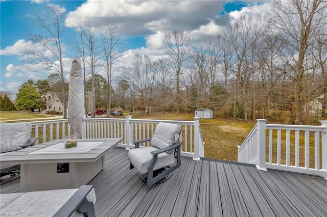 wooden terrace featuring a storage unit and a yard