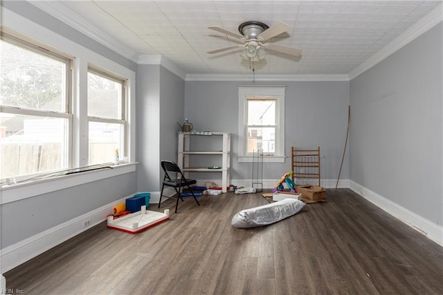 playroom featuring dark hardwood / wood-style flooring, ornamental molding, and ceiling fan