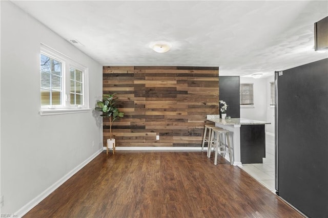 interior space featuring dark hardwood / wood-style floors and wood walls