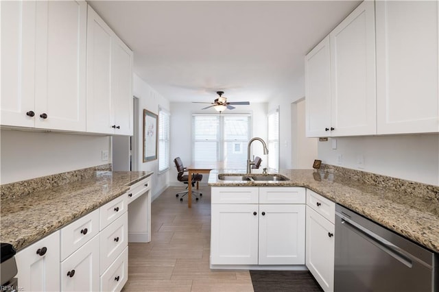 kitchen featuring sink, dishwasher, light stone counters, white cabinets, and kitchen peninsula