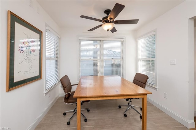 office with light hardwood / wood-style floors and ceiling fan