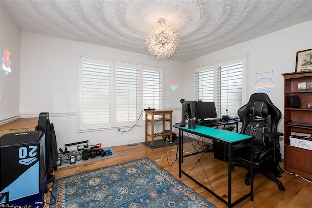 office space with hardwood / wood-style floors, a chandelier, and a textured ceiling