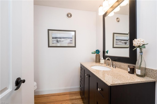 bathroom with hardwood / wood-style flooring, vanity, and toilet