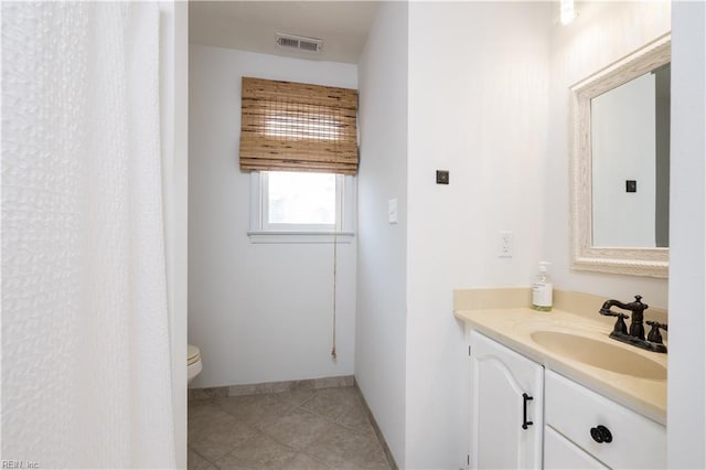 bathroom featuring vanity, toilet, and tile patterned flooring