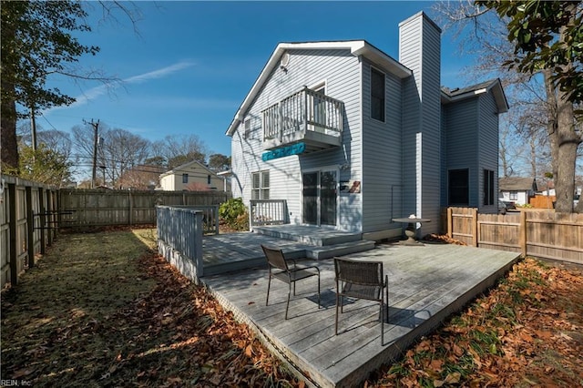 back of house with a wooden deck and a balcony