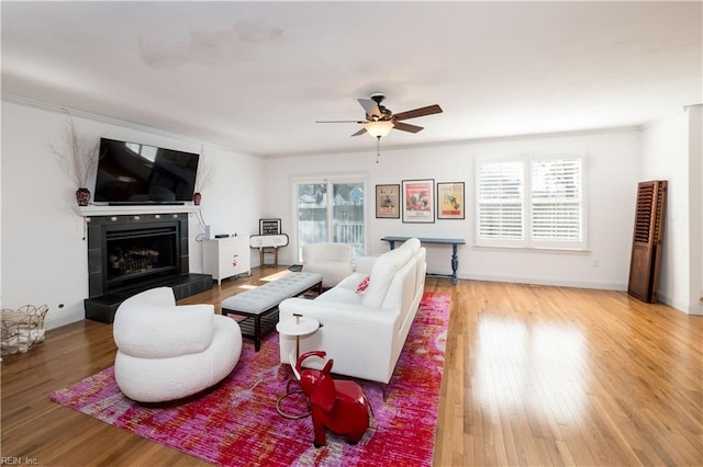 living room with ceiling fan, hardwood / wood-style flooring, a fireplace, and a wealth of natural light