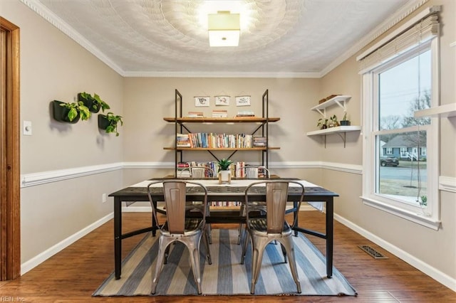 dining area with wood-type flooring and ornamental molding