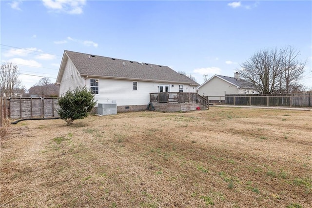 rear view of house featuring a lawn, central air condition unit, and a deck