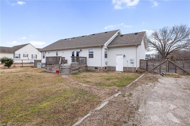 back of property featuring a wooden deck and a yard