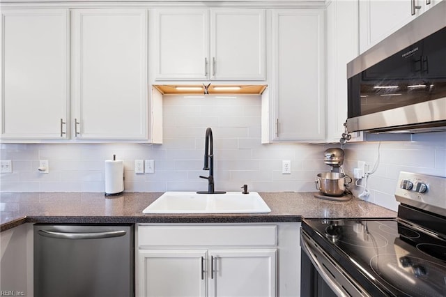 kitchen featuring sink, decorative backsplash, white cabinets, and appliances with stainless steel finishes