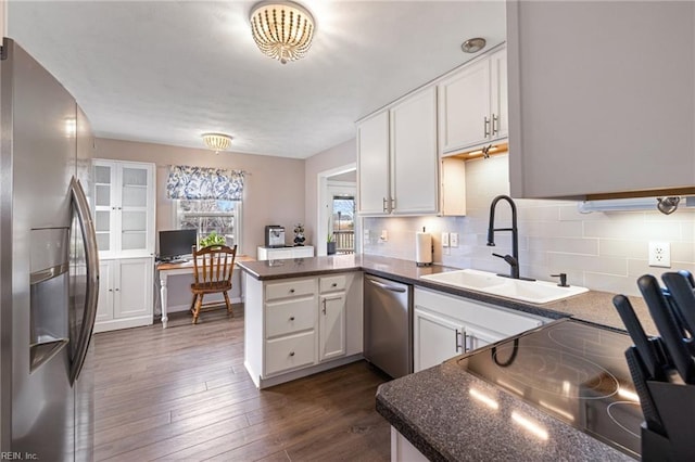 kitchen featuring sink, stainless steel appliances, kitchen peninsula, and white cabinets