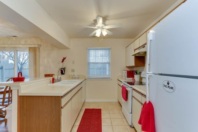 kitchen featuring white appliances, a healthy amount of sunlight, sink, and light tile patterned floors