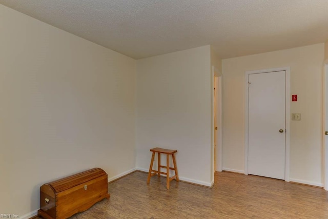 spare room with light hardwood / wood-style flooring and a textured ceiling