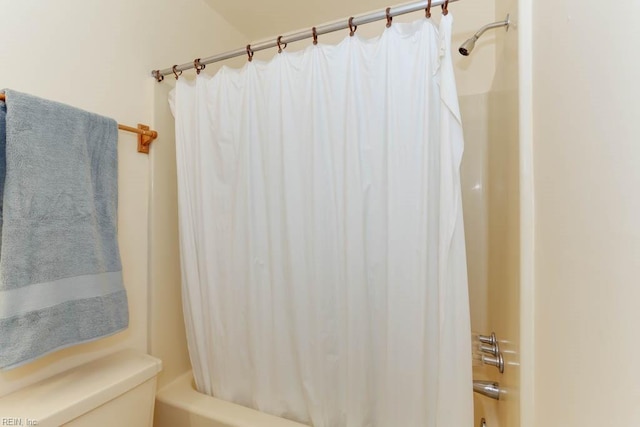 bathroom with toilet and shower / bath combo with shower curtain