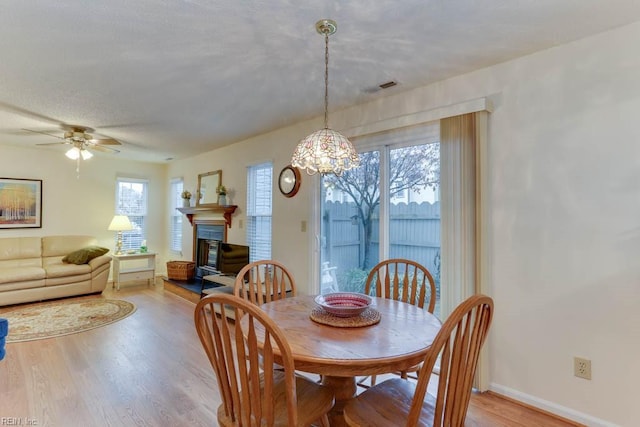 dining area with ceiling fan, a textured ceiling, and light wood-type flooring