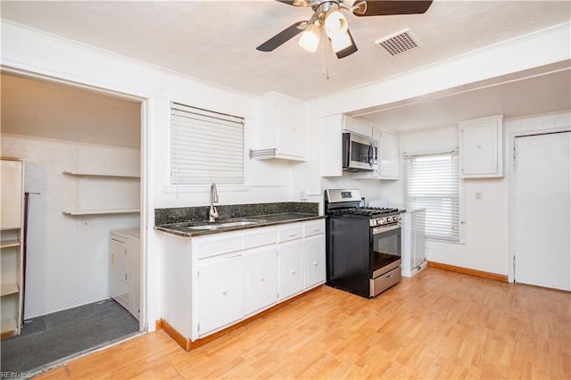 kitchen with light wood-type flooring, appliances with stainless steel finishes, sink, and white cabinets